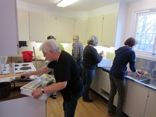 Styrelsemedlemmar återställer köket efter målningsarbete.